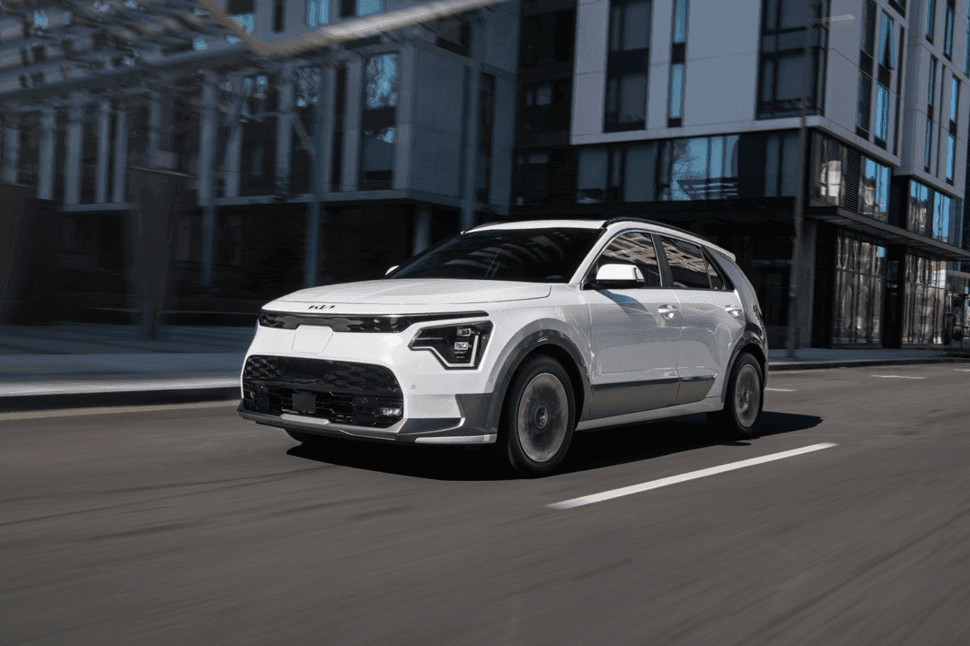 Vue 3/4 avant du Kia Niro EV 2025 roulant sur une route urbaine.